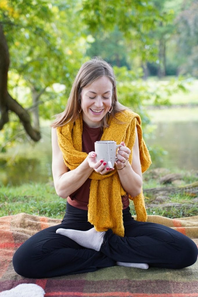 Meditation am See lächelnd mit Tee